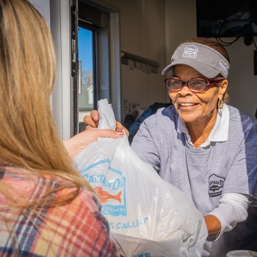 Employee handing a customer their Captain D's order